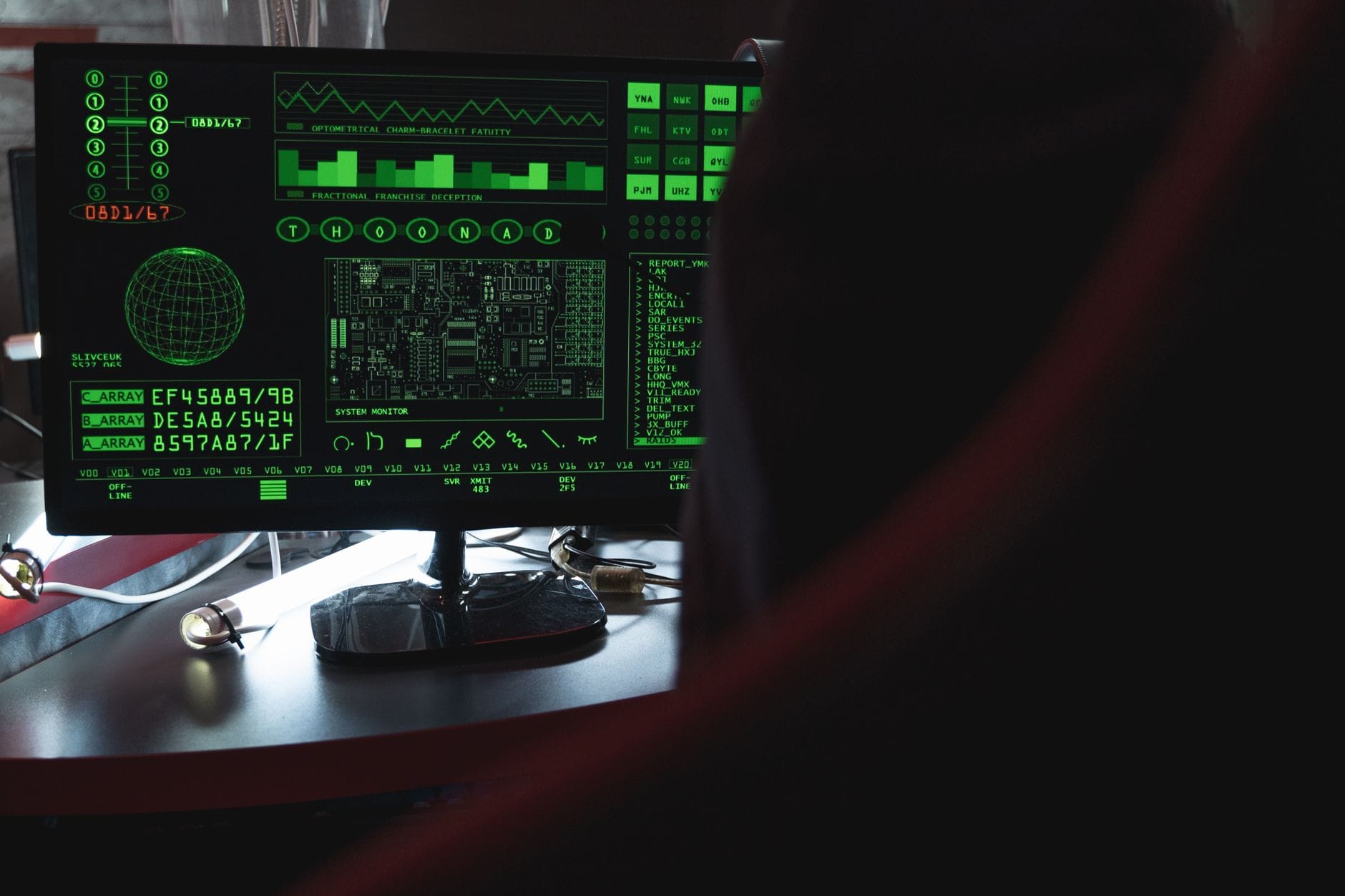 Monitor z zielonym kodem na ekranie w ciemnym pomieszczeniu